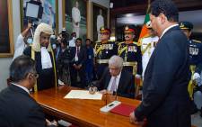 This handout photograph taken on 21 July 2022 and released by Sri Lanka's Parliament shows president-elect Ranil Wickremesinghe (C) signing documents during the swearing-in ceremony as Sri Lanka's President, at the parliament in Colombo. Picture: Ishara Kodikara/Sri Lanka's parliament/AFP