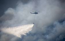 Two Working on Fire choppers assisted firefighters by water-bombing the flames on the mountain above Hout Bay on Tuesday 3 March 2015. Picture: Aletta Gardner/EWN.