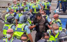Police detain a demonstrator protesting against COVID-19 vaccine mandates and restrictions gather outside of the New Zealand Parliament grounds in Wellington on 2 March 2022. Picture: Dave Lintott/AFP