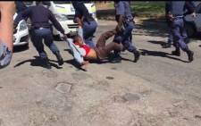 FILE: A man is dragged into a police van after officers fired rubber bullets at protesting students at Rhodes University on 28 September 2016. Picture: Screebgrab