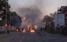 A protester taunts police as service delivery riots continued in Langa, Cape Town, where residents protesting against what they say is an unfair allocation of newly built houses in the township, closed Bhunga Avenue by burning tyres and littering the road with debris. Picture: Thomas Holder/EWN