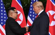 FILE: North Korea's leader Kim Jong Un shakes hands with US President Donald Trump at the start of their historic US-North Korea summit at the Capella Hotel on Sentosa island in Singapore on 12 June 2018. Picture: AFP
