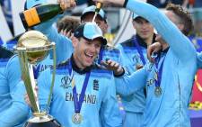 England's captain Eoin Morgan is covered in champagne as he poses with the World Cup trophy as England's players celebrate their win after the 2019 Cricket World Cup final between England and New Zealand at Lord's Cricket Ground in London on 14 July 2019. Picture: AFP