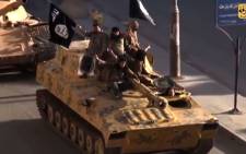 FILE: A screen grab taken from a video released on 1 July, 2014, allegedly shows members of the Islamic State parading on top of a tank on a street in the northern rebel-held Syrian city of Raqa. Picture: AFP.