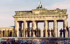 A file photo dated 11 November 1989 shows East German border guards standing on the Berlin Wall at the Brandenburg Gate in West Berlin, Germany. Picture: EPA.