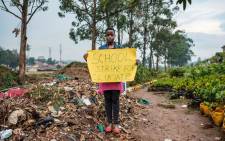 Leah Namugerwa, a 15-year-old climate activist, holds a placard in Kampala on September 4, 2019. She misses out on school every Friday to raise awareness about climate change and the environment, to secure her future. Picture: SUMY SADURNI / AFP