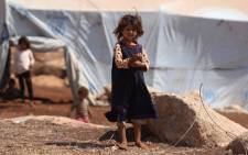 A displaced Syrian girl who fled from regime raids stands outside her tent in a camp in Kafr Lusin near the border with Turkey in the northern part of Syria's rebel-held Idlib province on 9 September 2018. Picture: AFP.