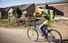 FILE: A young boy cycles holding an ANC poster. Picture: Thomas Holder/EWN.