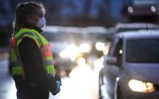 FILE: A German police officer wearing a facemask controls drivers at the French and German border between the cities of Strasbourg and Kehl on 12 March 2020 as part of measures taken due to the COVID-19 outbreak in Europe. Picture: AFP.
