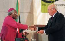 This file photo taken on 21 August 1996 shows former South African president FW de Klerk (R), handing over the party's submission to Archbishop Desmond Tutu, head of the Truth and Reconciliation Commission (TRC) during the National Party's submission before the TRC in Cape Town. Picture: Anna Zieminski/AFP.