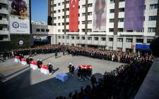 Turkish police officers stand to attention next to the coffins of their comrades as others parade with a coffin during a funeral ceremony at Istanbul's police headquarters on December 11, 2016, a day after twin bombings. Picture:  AFP.