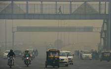 FILE: Motorists are seen along a busy road amid heavy smog in New Delhi. Picture: AFP