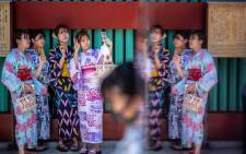 Women wearing yukatas, a traditional Japanese summer outfit, pose for selfies with their mobile phones at Sensoji temple in Tokyo on 22 July 2021, on the eve of the start of the Tokyo 2020 Olympic Games. Picture: Philip Fong/AFP