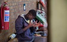 A displaced foreign national says a prayer at the DK Williams Community Centre in Katlehong. Picture: Kayleen Morgan/EWN
