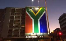 FILE: The SA flag now hangs in the prime ad space once home to the #ZumaMustFallBillboard. Workers busy adjusting edges. Picture: Natalie Malgas/EWN.