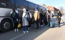 University students, including many from Nigeria, fleeing from the Ukrainian capital Kyiv, stow their luggage as they get on their transport bus close to the Hungarian-Ukrainian border in the village of Tarpa in Hungary on 28 February 2022. Picture: Attila KISBENEDEK/AFP