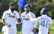 Sri Lanka's Prabath Jayasuriya (L), Dimuth Karunaratne (C) and Niroshan Dickwella celebrate the wicket of New Zealand's Tom Latham during the fifth day of the first Test match between New Zealand and Sri Lanka at Hagley Oval in Christchurch on 13 March 2023. Picture: Sanka Vidanagama/AFP