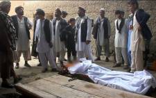 Afghan residents and relatives stands over the bodies of victims after a gunfight broke out at a wedding party at Deh Salah district of Baghlan Province on 27 July 2015. Picture: AFP.