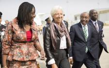 International Monetary Fund Managing Director Christine Lagarde (C), accompanied by Nigerias Finance Minister Kemi Adeosun (L) and Nigerias Central Bank Governor Godwin Emefiele, at the Nnamdi Azikiwe International Airport on 4 January, 2016 in Abuja. Picture: AFP.