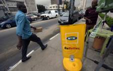 FILE: A man walks past a MTN notice board in Lagos, on 27 October 2015. Nigeria's telecommunications regulator has fined South African mobile giant MTN $5.2 billion for missing a deadline to disconnect unregistered SIM cards. Picture: AFP