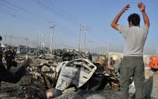 A man looks at the carnage outside a petrol station after a suicide attack in Kabul on September 18, 2012. Picture: AFP.