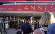 FILE: A Police officers stands guard as people wait outside the main entrance of the Festival's Palace on 20 May 2017 after it was evacuated over a suspicious package, at the 70th edition of the Cannes Film Festival in Cannes, southern France. Picture: AFP.