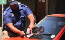 A Johannesburg metro police officer gives a fine. Picture: EWN