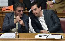 FILE: Greek Prime Minister Alexis Tsipras (R) and Finance Minister Eyclid Tsakalotos attend a parliamentary session in Athens on 15 July, 2015. Picture: AFP