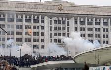 This image grab shows protesters near an administrative building during a rally over a hike in energy prices in Almaty on 5 January 2022. Protesters stormed the mayor's office in Kazakhstan's largest city Almaty on 5 January 2022 as unprecedented unrest in the Central Asian nation spun out of control. Picture: AFP
