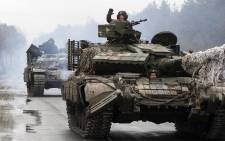 Ukrainian servicemen ride on tanks towards the front line with Russian forces in the Lugansk region of Ukraine on 25 February 2022. Picture: Anatolii Stepanov/AFP