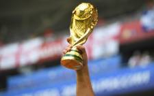 A fan raises a replica of the World Cup trophy. Picture: AFP.