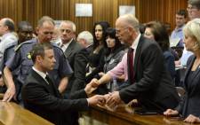 Oscar Pistorius holds the hands of family members as he is taken down to the holding cells after being sentenced to five years imprisonment for the culpable homicide death of his girlfriend Reeva Steenkamp. Picture: Pool.