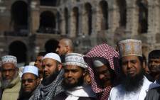 Muslim men gather to attend Friday prayers near Rome's ancient Colosseum on October 21, 2016 to protest against the closure of unofficial mosques. The Muslim community of Rome gathered by the Colosseum to pray and demonstrate against the alleged shutting down by police of unofficial mosques. Picture: AFP