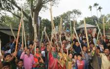 Bangladeshi villagers cheer after a voting station was attacked by protestors in the northern town of Bogra on January 5, 2014. Protestors firebombed polling stations and attacked police as Bangladesh went ahead with a violence-plagued election boycotted by the opposition. Picture: AFP.