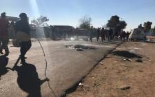 Police monitoring a protest in Primrose on the East Rand where residents of the Makause Informal Settlement have barricaded the main roads with burning tyres on 22 May 2017. Picture: Kgothatso Mogale/EWN.