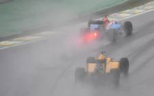 Manor’s Racing’s German driver Pascal Wehrlein (top) powers his car ahead of Renault Sport F1 Team’s Danish driver Kevin Magnussen under the rain during the Brazilian Grand Prix at the Interlagos circuit in Sao Paulo, Brazil, on 13 November, 2016. Picture: AFP.
