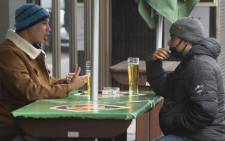 FILE: Two men enjoy some beers at a streetside bar in the city centre in Cape Town, on 18 August 2020 after South Africa moved to level 2 of the coronvirus lockdown. Picture: AFP
