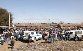 Mohlakeng community members hold a meeting with community leaders and members of the South African Police Service (SAPS) at a Mohlakeng Hostel, near Randfontein, on 8 August 2022, during a demonstration by residents against illegal mining and crome in their area. Picture: PHILL MAGAKOE / AFP