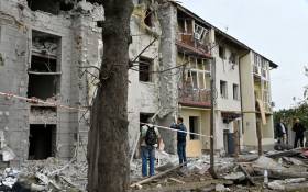 Local residents stand outside their building partially destroyed by a missile strike on Kharkiv on 12 September 2022 amid the Russian invasion of Ukraine. Picture: SERGEY BOBOK/AFP