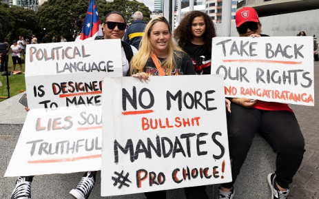 Protesters hold placards as they gather in front of the parliament building in Wellington on February 8, 2022, during a demonstration against Covid restrictions, inspired by a similar demonstration in Canada. Picture: Marty Melville / AFP.