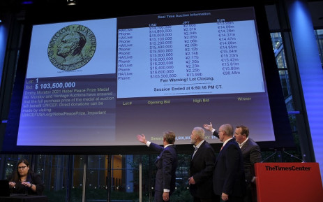 Russian journalist Dmitry Muratov (2L) reacts on stage to the bid of $103.5 million to buy his 2021 Nobel Peace Prize medal in New York, on June 20, 2022. Picture: Kena Betancur / AFP.