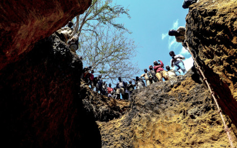 Illegal miners stand on top of a ditch where they search for rubies on 3 August 2018, in Nthoro village, on the outskirts of the mining town of Montepuez, Mozambique. Picture: AFP.