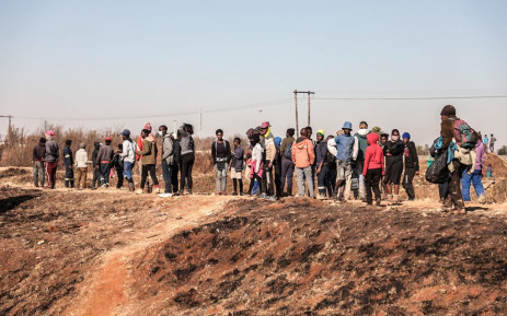 People outside Chris Hani Crossing Mall in Vosloorus, waiting for police to leave the area after looting on 14 July 2021. South Africa has been battling looting and riots since Saturday. Picture: Abigail Javier/Eyewitness News