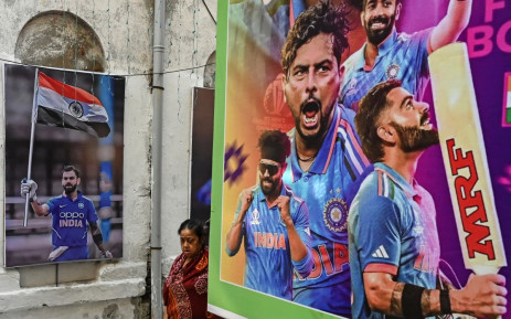 A woman walks past posters of team India's players along a street in Kolkata on 19 November 2023 prior to the 2023 ICC Men's Cricket World Cup final match between India and Australia at the Narendra Modi Stadium. Picture: AFP