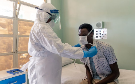 A medical staff member wearing protective equipment places a face mask on a mock patient at the Wilkins Infectious Diseases Hospital in Harare on 11 March 2020. Picture: AFP
