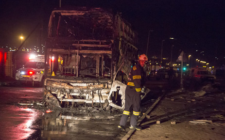 A fireman walks passed the wreckage of the Intercape bus that was petrol bombed in Strand, Cape Town. Picture: Thomas Holder/EWN