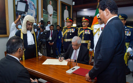 This handout photograph taken on 21 July 2022 and released by Sri Lanka's Parliament shows president-elect Ranil Wickremesinghe (C) signing documents during the swearing-in ceremony as Sri Lanka's President, at the parliament in Colombo. Picture: Ishara Kodikara/Sri Lanka's parliament/AFP