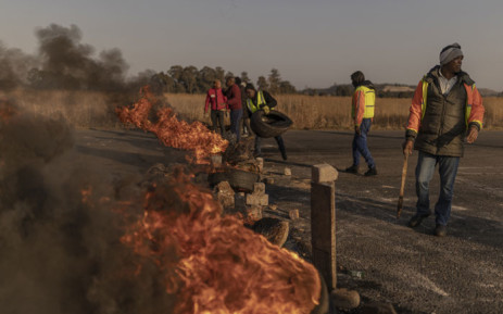 Residents from Kagiso township build a barricade by setting tires on fire during a protest against illegal mining and rising crime in the area in Kagiso on 4 August 2022. Picture: GUILLEM SARTORIO/AFP