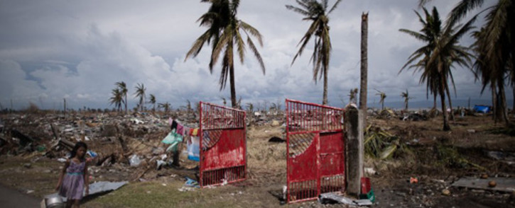 A typhoon victim walks past land ravaged by Typhoon Haiyan in Tacloban, on the eastern island of Leyte on 13 November, 2013. Picture:AFP