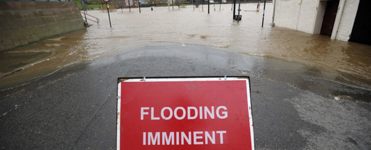 A sign warning of imminent flooding is seen on the edge of floodwaters along the River Nith that burst its banks in Dumfries, southern Scotland, on December 30, 2015 after heavy rainfall brought by Storm Frank. Storm Frank battered Scotland leaving thousands of homes without power and severe floods in its wake. Picture: AFP